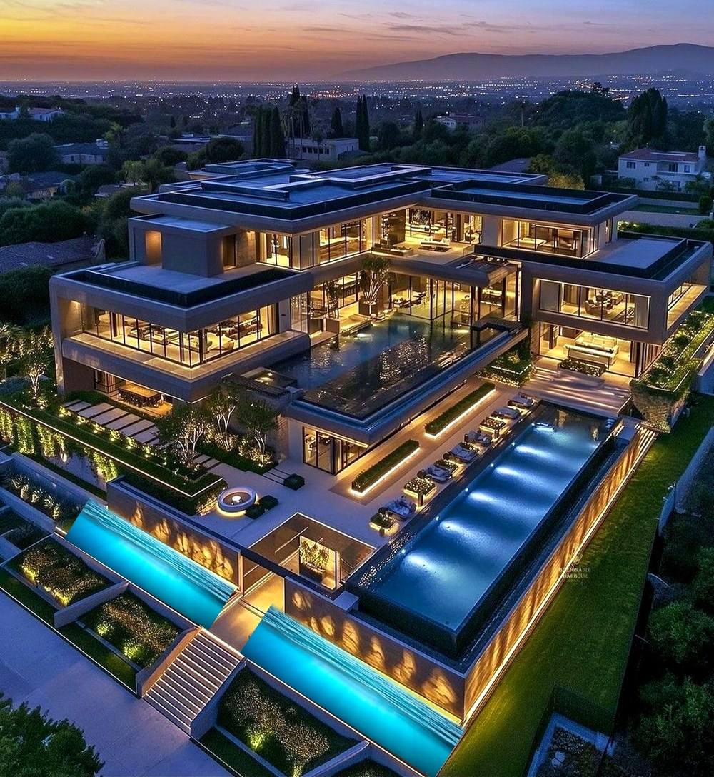 The Avellora Estate — hillside modern residence with terraced infinity pools, illuminated at dusk